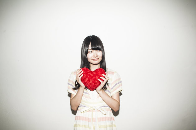 Asian young woman holding heart shaped cushion