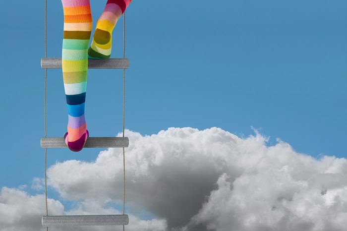 Adventure, escapism, dreams or aspirations... rainbow stocking legs climb above the clouds. Portrait version available.